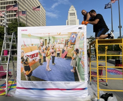Two people on scaffolding putting up a photo entry
