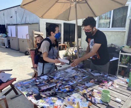 A man and a woman with a young child looking over photo entries