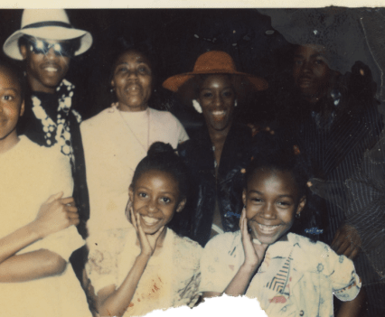 An old photograph of a family smiling at the camera