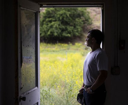 A man standing in an open doorway looking out
