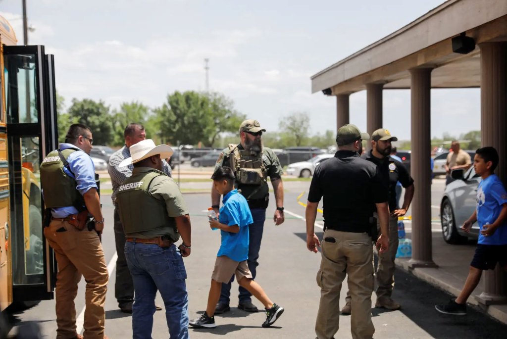 Children got on a school bus as law enforcement personnel guarded the scene of a shooting Tuesday near Robb Elementary School in Uvalde.