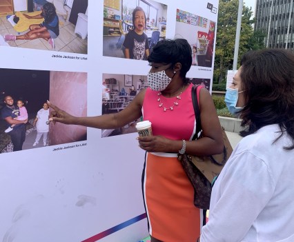 A woman pointing to a posted photo entry