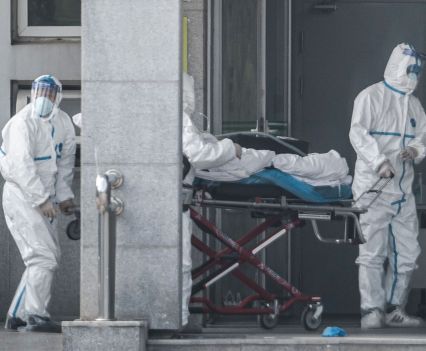 Infected man transported in hospital by healthcare workers in Tyvek suits