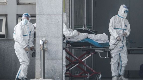 Infected man transported in hospital by healthcare workers in Tyvek suits