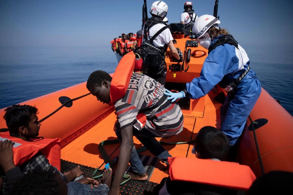 Rescued migrants in lifejackets aboard rescue boat