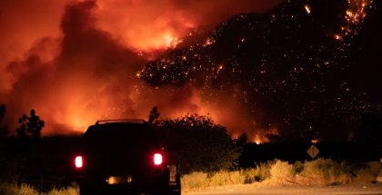 A motorist watches from a pullout on the Trans-Canada Highway as a wildfire burns on the side of a mountain in Lytton, B.C., on July 1.