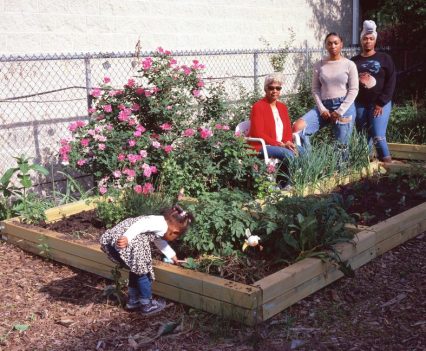 Gina Jamison (in red) and her daughter and granddaughters pose at the community garden of Garfield Park on June 2, 2021 ©Garfield Park Citizen Archives 2021, photo by Samantha Cabrera Friend