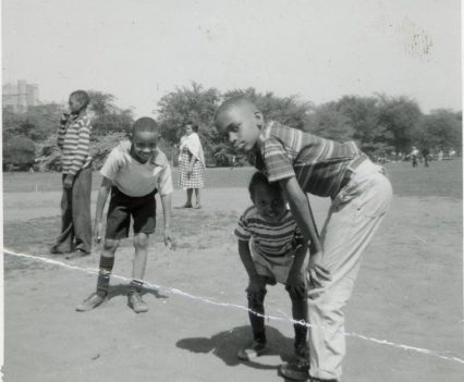 An old photograph of young boys playing outside on a field