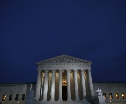 A view of the front of the Supreme Court building at dusk.