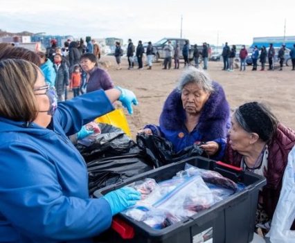 Inuit elders gathered around boxes