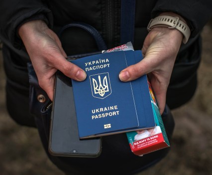 Hands holding a passport, medicine and phone
