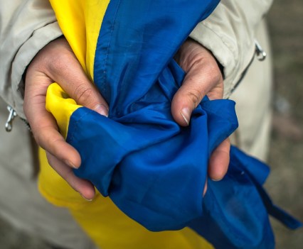 Hands holding a Ukrainian flag