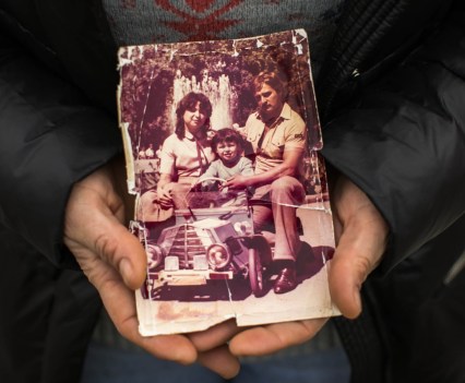 Hands holding a weathered family photograph