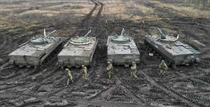 Russian service members walk past BMP-3 infantry fighting vehicles during tactical combat exercises in the Rostov region, Russia, Dec. 10, 2021.