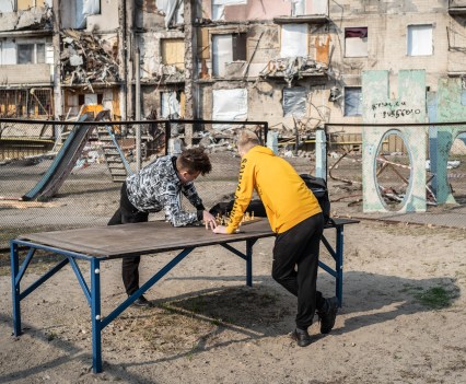 Sasha and Anton, 5, playing chess near the ruined house at Kyiv, Ukraime