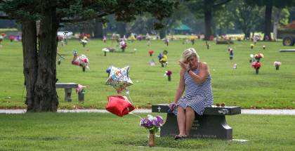 Michele Crockett, mother of Max Gilpin, visits at the grave of her son. It would have been Max Gilpin's 26th birthday, and she brought balloons as she does every year. He died after becoming overheated at football practice at Pleasure Ridge Park High School in 2008. July 19, 2019