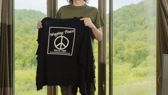 Photographed in June 2022 at his home in La Crosse, Wis., Olsen displays the “Veterans for Peace” shirt he was wearing when police shot him. Lyndon French for Long Lead