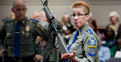 FILE - Firearms training unit Det. Barbara J. Mattson, of the Connecticut State Police, holds up a Bushmaster AR-15 rifle, the same make and model of gun used by Adam Lanza in the December 2012 Sandy Hook School shooting, during a hearing of a legislative subcommittee in Hartford, Conn., on Jan. 28, 2013. Citing a U.S. Supreme Court decision earlier this year, gun rights groups and firearms owners filed a new lawsuit Thursday, Sept. 29, 2022, in federal court in another attempt to overturn Connecticut's ban on certain semiautomatic rifles that was enacted in response to the Sandy Hook Elementary School shooting. (AP Photo/Jessica Hill, File)