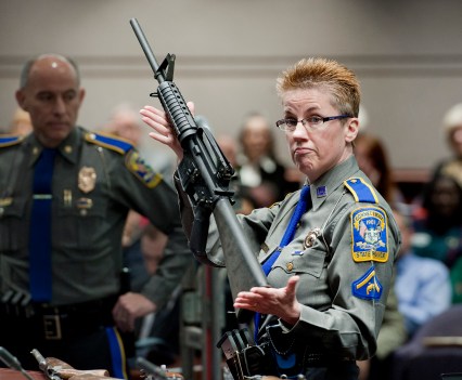 FILE - Firearms training unit Det. Barbara J. Mattson, of the Connecticut State Police, holds up a Bushmaster AR-15 rifle, the same make and model of gun used by Adam Lanza in the December 2012 Sandy Hook School shooting, during a hearing of a legislative subcommittee in Hartford, Conn., on Jan. 28, 2013. Citing a U.S. Supreme Court decision earlier this year, gun rights groups and firearms owners filed a new lawsuit Thursday, Sept. 29, 2022, in federal court in another attempt to overturn Connecticut's ban on certain semiautomatic rifles that was enacted in response to the Sandy Hook Elementary School shooting. (AP Photo/Jessica Hill, File)