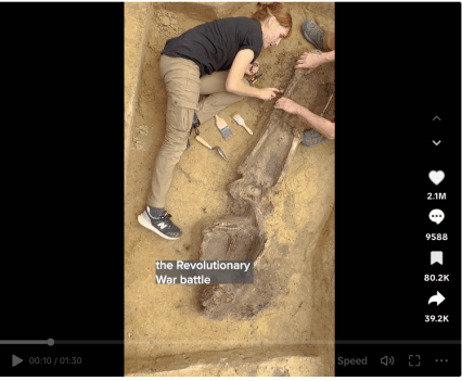 Screenshot from the TikTok video showing archaeologists carefully unearthing a skeleton in the dirt