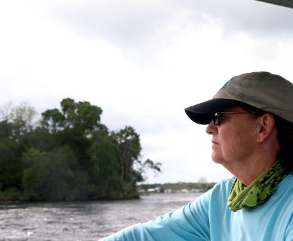 Capt. Karen Chadwick, a fierce advocate for dam removal who spends most days on the water, gazes off the side of her boat on the Ocklawaha River. (Alan Halaly/WUFT News)
