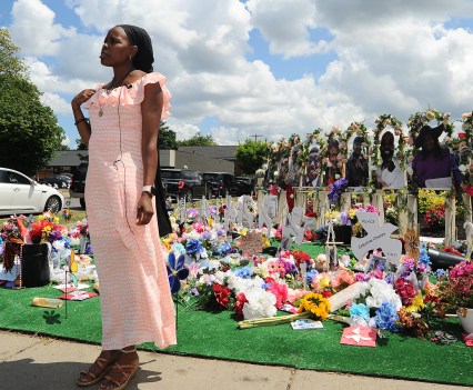 BUFFALO, NY - JULY 14: Fragrance Harris Stanfield, assistant customer service representative at the Tops Friendly Market on Jefferson Avenue, is interviewed at a "Memorial Garden" filled with flowers, photos and mementos outside the store on July 14, 2022 in Buffalo, New York. The store was the scene of a mass shooting on May 14, 2022 when accused shooter Payton Gendron killed 10 Black people and injured three others in what is believed to be a racially-motivated attack. The market will reopen to the public Friday after extensive renovations to the building. (Photo by John Normile/Getty Images)