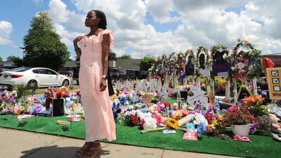 BUFFALO, NY - JULY 14: Fragrance Harris Stanfield, assistant customer service representative at the Tops Friendly Market on Jefferson Avenue, is interviewed at a "Memorial Garden" filled with flowers, photos and mementos outside the store on July 14, 2022 in Buffalo, New York. The store was the scene of a mass shooting on May 14, 2022 when accused shooter Payton Gendron killed 10 Black people and injured three others in what is believed to be a racially-motivated attack. The market will reopen to the public Friday after extensive renovations to the building. (Photo by John Normile/Getty Images)