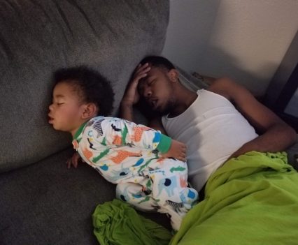 Jeremiah Triplett and his son, J.J., asleep on a couch in 2018.