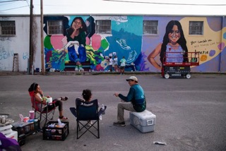 Abel Ortiz-Acosta chats with the artists while family members of Maite Rodriguez paint a small section of the mural in her memory in Uvalde on July 24, 2022.