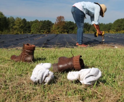 Woman with boots off working to help elders' farm.