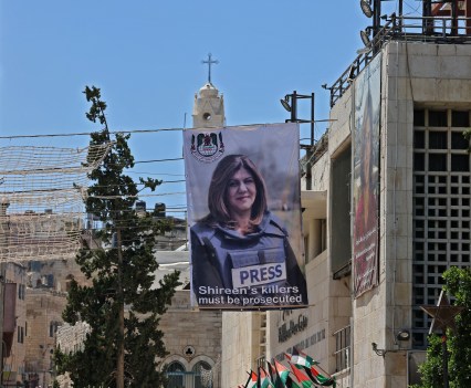 Banners depicting slain Palestinian-American journalist Shireen Abu Akleh hang on a building overlooking the Church of the Nativity in Bethlehem in the occupied West Bank, on July 14, 2022, ahead of the arrival of the US President for an official visit.