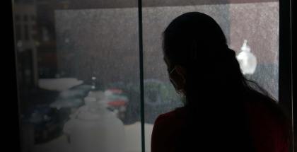 Silhouette of a woman looking out a window