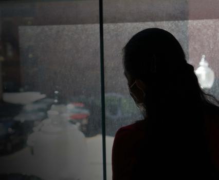 Silhouette of a woman looking out a window