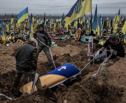 Grave diggers lower the coffin of Ukrainian soldier Roman Vakulenko, 52, who was killed by Russian artillery in the city of Bakhmut on October 25, at the military cemetery in Kharkiv in northeastern Ukraine, November 3, 2022.