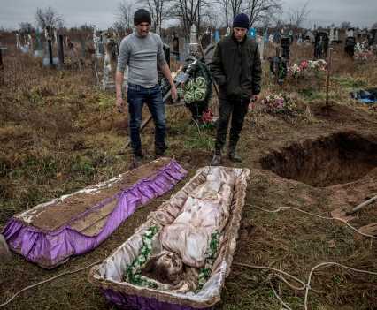 Local residents help police and war crimes investigators exhume the body of Viktoria Volokhova, a 15-year-old girl who local residents said had been executed by Russian forces, along with seven men, six of whose bodies had been exhumed the day before from the garden of a nearby house, in the recently liberated southern Ukrainian village of Pravdyne, November 29, 2022. Eight people were killed at the house when an informant told Russian forces the civilians were passing on information to Ukrainian military sources, according to local residents. The bodies were found with some of their hands tied, their eyes blindfolded, and shot at close range in the back of the head. Afterwards the house was blown up and the bodies were later buried in a grave beside the house by a local resident.