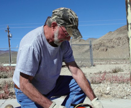 Photo of a man bending down and monitoring wells in Silver Peak