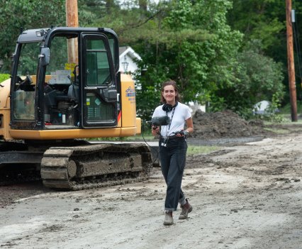 Photo of a female reporter on the scene of the floods in Vermont