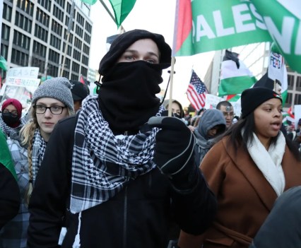 Photo of a group of people, with three women at the front, of a Pro-Palestine prostest