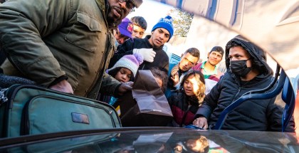 Photo of group led by an African American man donating clothes and shoes to asylum seekers amid the cold temperatures outside the Chicago Police Department’s 2nd District station in Fuller Park