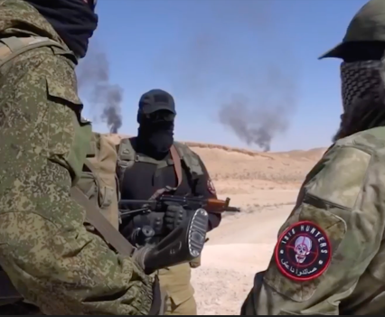 Photo of military men, one holding a gun, as spots of smoke are seen in the distance