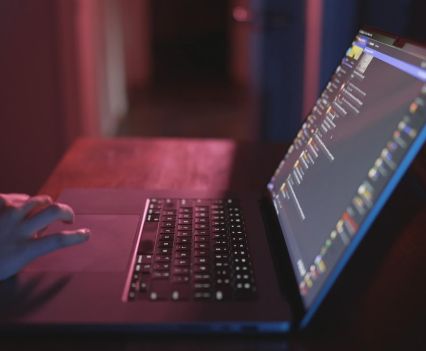 Photo of hand on a laptop with a dark screen