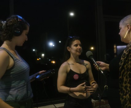 Photo of a woman being interviewed at night