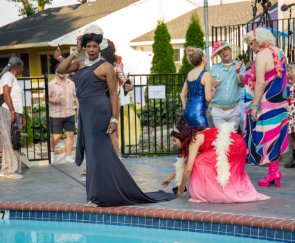 Group of people dressed in elegant attire surrounding a pool