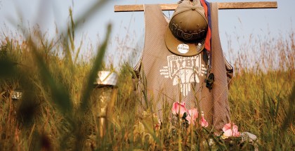 Cross memorial with a hat hanging on it