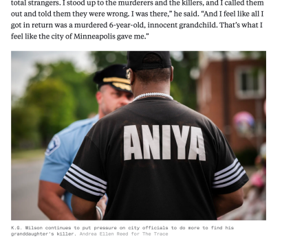 A man in a black shirt has his back to the camera. Over his shoulder is a blurry officer in uniform