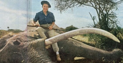 Virginia Kraft sits atop an African elephant, rifle in hand.