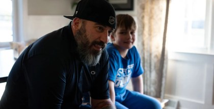 Photo of a man sitting in front of his son who has struggled with depression